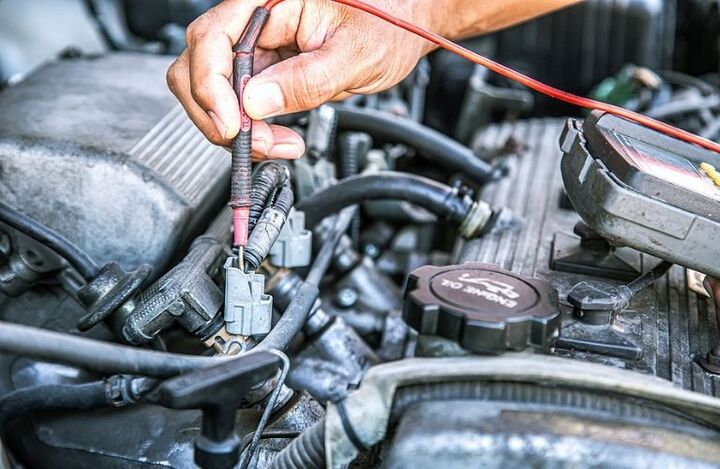mechanic checking electrical systems of vehicle