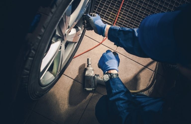 a mechanic checking the tire of a car