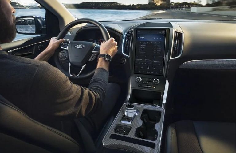 Interior seat with a man holding the steering wheel of 2022 Ford edge is shown